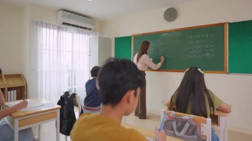 Group of students learning with teacher in classroom at elementary school.