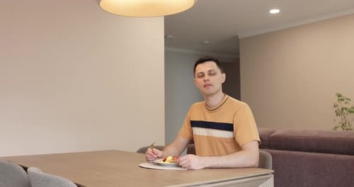 Young Adult Man Eating a Meal at Home