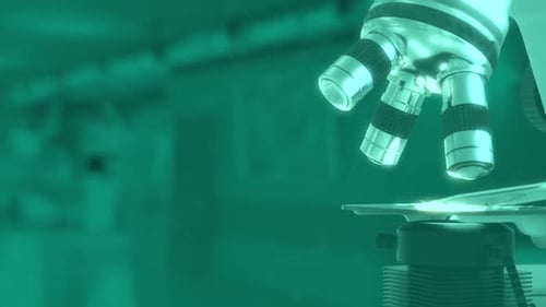 Close-up of microscope in laboratory setting with green tint