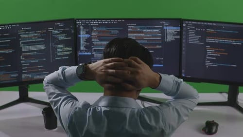 Asian Man Developer Having Headache While Write Code With Multiple Computer Screens In Green Screen