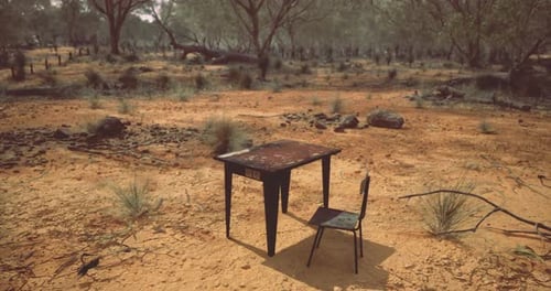 Solitary Desk and Chair Amidst a Barren Landscape at Dusk