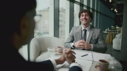 Geschäftsmann unterhält sich während eines Kaffeetreffens mit einem Kollegen