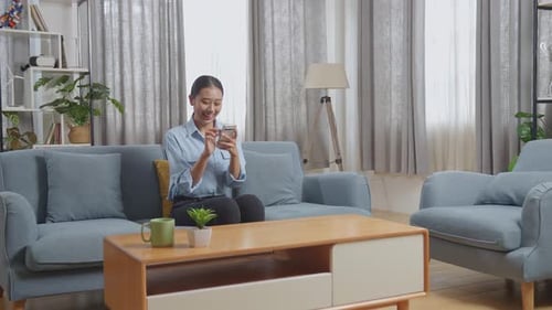 Young Woman Using Smartphone in Comfortable Home Interior