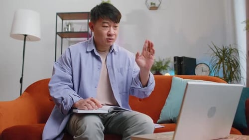 Adult on Video Call Taking Notes at Home