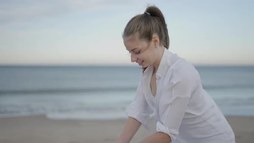 Joyful Caucasian Woman Performing Massage at the Beach Close Up Shot