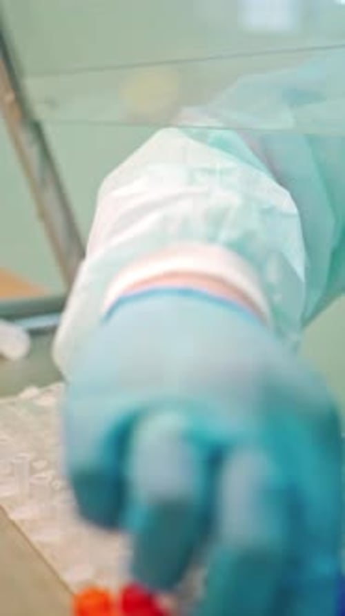 Gloved Hands Working with Pipette in Laboratory