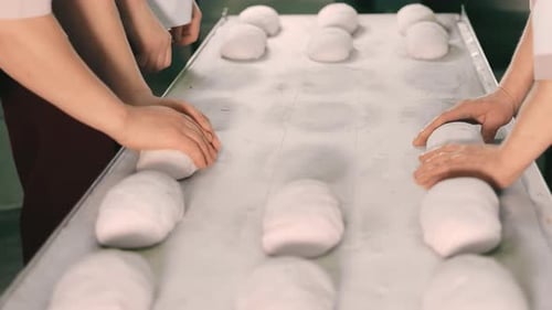 Skilled Workers Shaping Dough in Commercial Bakery