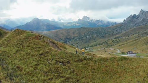 Couple of Tourists Stands on Pathway and Explores Mountain
