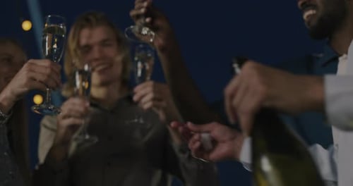 Grupo multiétnico de colegas tilintando taças de champanhe comemorando a promoção em um evento corporativo