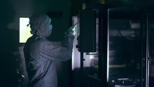 Pharmaceutical factory worker operates touch screen control panel at plant