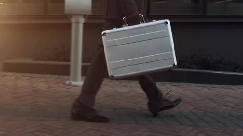 Business Man Walks with Briefcase in Golden Hour