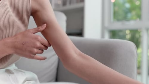 Unhappy Asian woman suffering from pain in arm