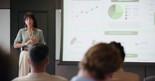 Businesswoman Giving Presentation to Audience at Conference