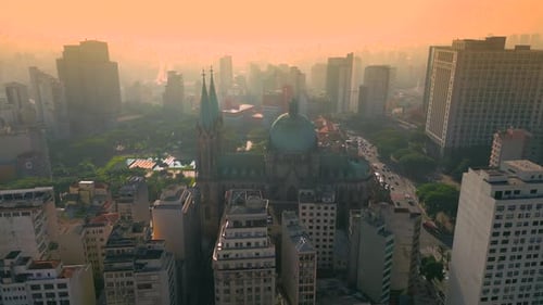 Vista aérea de São Paulo ao pôr do sol, mostrando os edifícios altos da cidade, a paisagem urbana e uma