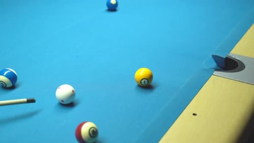 Billiard, verpasster Schuss. Blauer Tisch, rollende Bälle.
