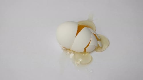 Ei wird auf isoliertem weißem Hintergrund geknackt