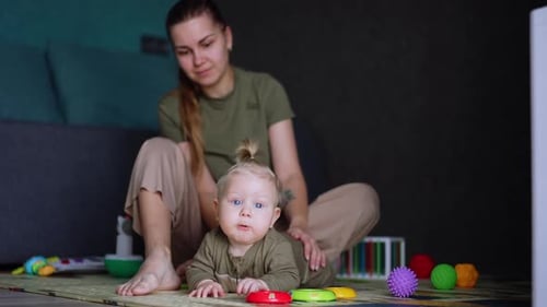 Mama und ihr Baby sitzen auf dem Boden. Der kleine Junge ist unglücklich und will weinen. Erziehungskonzept
.