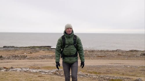 Man in Woolly Hat Hiking From Sea