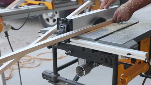 Woodworking Expert Uses Table Saw to Cut Wooden Strips at Outdoor Workshop