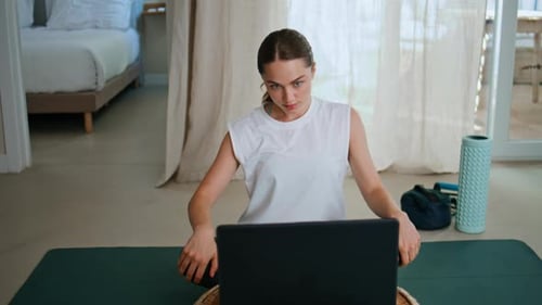 Sportswoman Browsing Laptop Video Sitting Yoga Mat at Modern Home Closeup