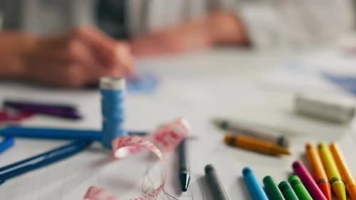 Close Up Of Designer's Hands Sketching Dress With Colored Pencil On Desktop, Creating Sample Of New