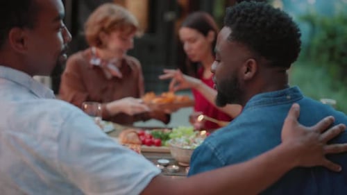 Friends Sharing Meal and Smiling Outdoors