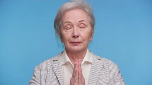 Senior Woman Puts Hands Together in Prayer Position