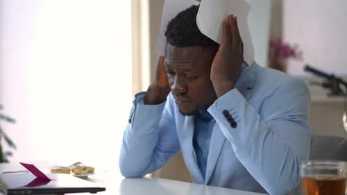 Distressed Man Holding Financial Report Over His Head