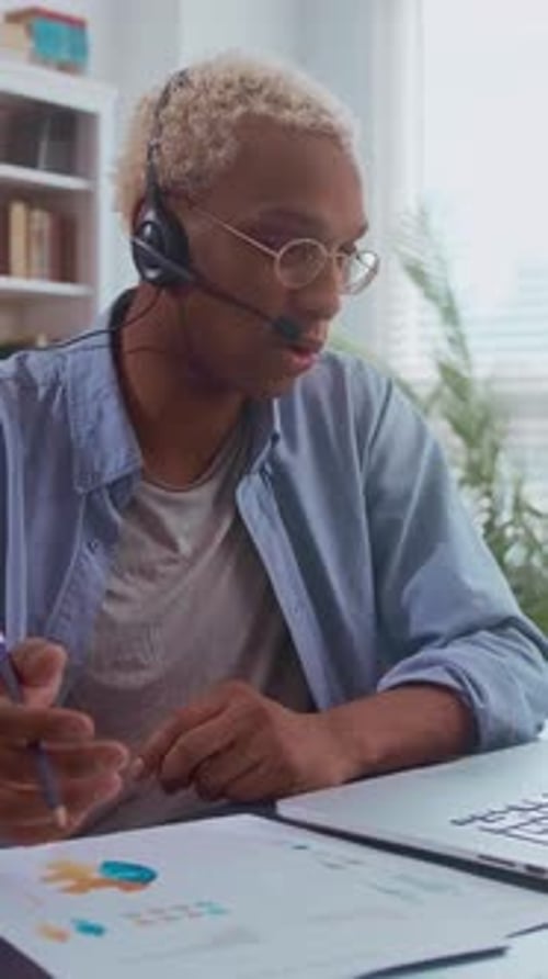 Jeune homme afro-américain travaillant à distance dans un bureau à domicile lumineux