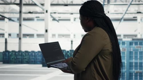 Data Center Technician Reviews Power Management Using Green Screen Laptop