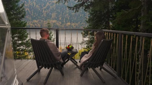 Woman and Man on Terrace at Table with Fruits