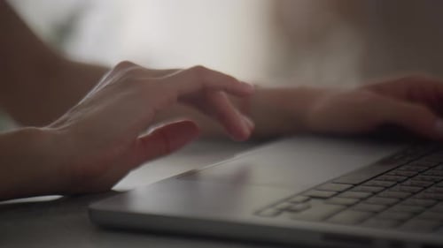 Primer plano de las manos navegando en el panel táctil del portátil