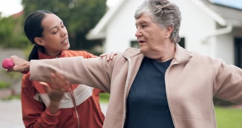 Adult Assisting Senior Woman with Arm Exercises