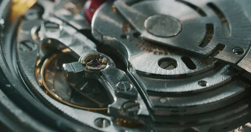 Slow motion close up of a professional watchmaker repairer working on a luxury mechanism watch gea