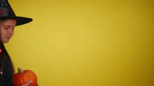 Girl Dressed as Witch with Pumpkin
