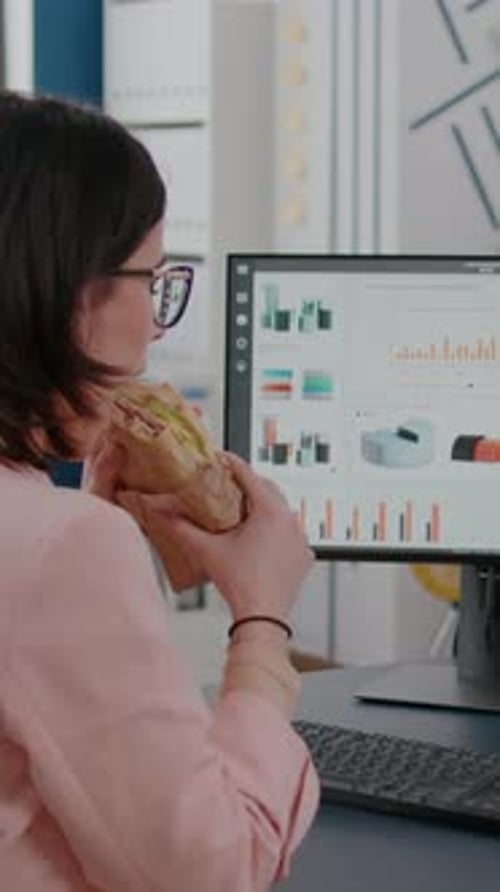 Vertikales Video Geschäftsfrau, die im Büro eines Startup-Unternehmens arbeitet und mittags Essen zum Mitnehmen hat