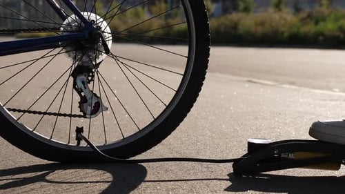 Pumping Up Bicycle Tire on an Urban Road