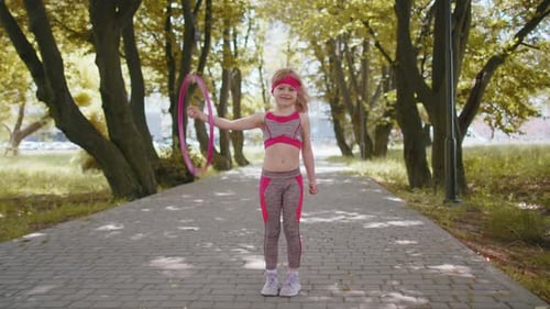Athletic Fitness Children Girl Training Playing Twisting Hula Hoop Circle Ring on Hand in Park