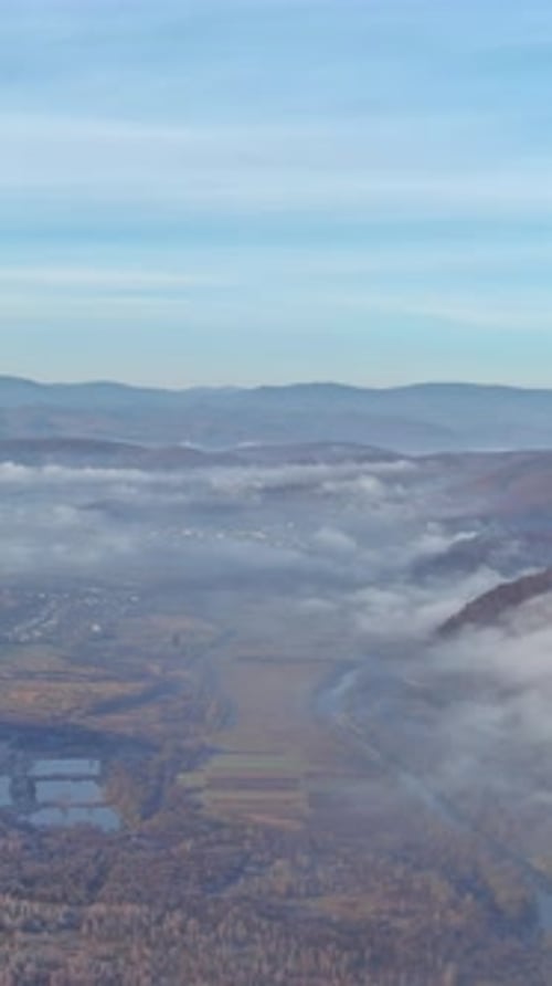 Scenic Mountain View with Fog Rolling Over a Valley in the Early Morning