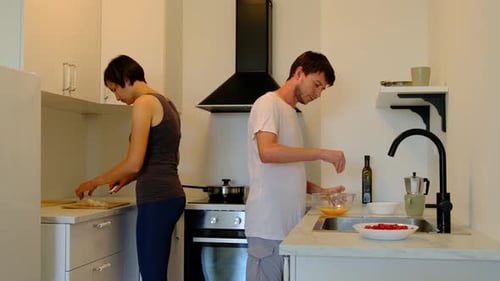 Adults Prepare Food Together in Modern Kitchen