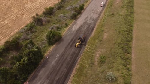 Road machinery repairing the road of a construction site.