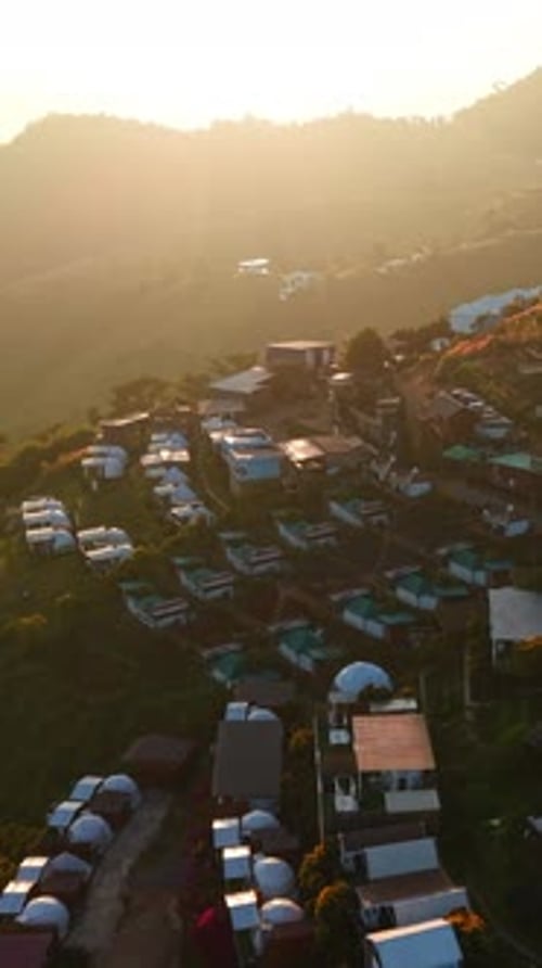 Pueblo turístico en la ladera de una montaña iluminada por la puesta de sol