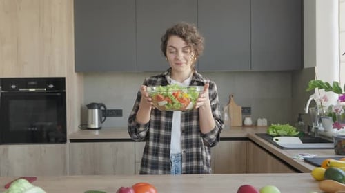 Woman Smiles Holding Bowl of Fresh Salad