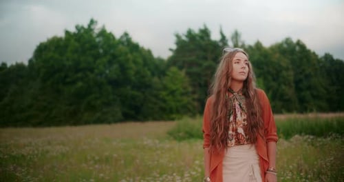 A Thoughtful Woman Against A Background Of A Forest And Meadow