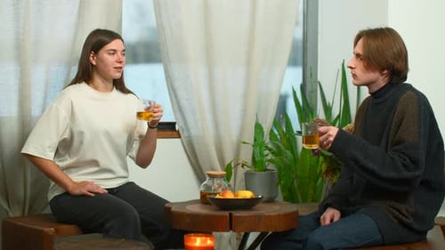 Students communicate and drink tea in cafe. Media. Young man and woman are drinking tea and talking
