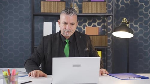 Professional Man Works Thoughtfully at Desk