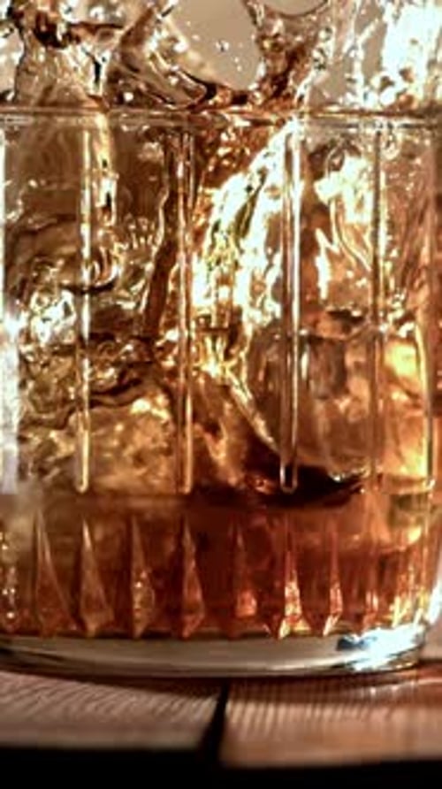 Ice Falls Into a Glass of Whiskey Filmed on a Highspeed Camera at 1000 Fps