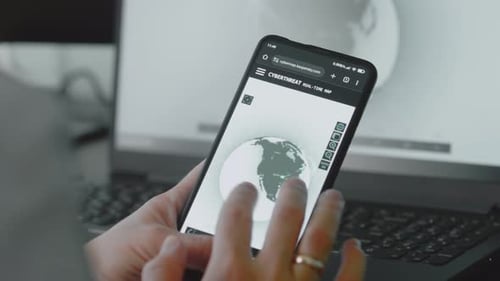 Adult Using Smartphone Showing Global Cyberthreat Map