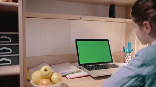 Student Studies at Desk with Laptop Green Screen