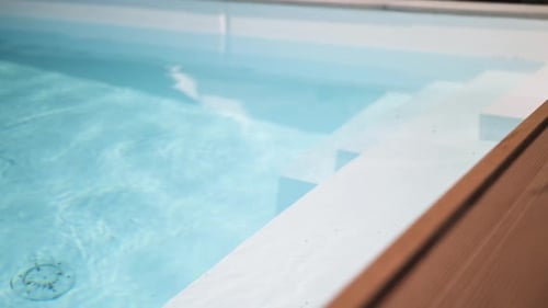 Detail der Treppe eines luxuriösen Privatpools im Sommer mit eleganter Kamerabewegung